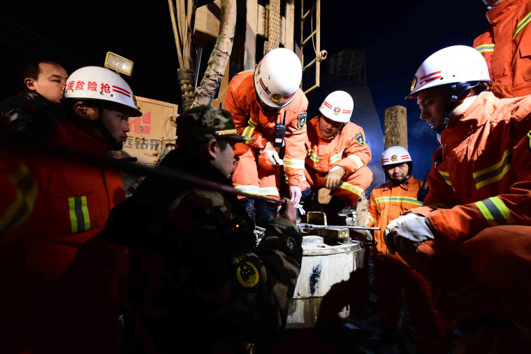 Image: Rescuers try to contact the trapped people at a collapsed mine