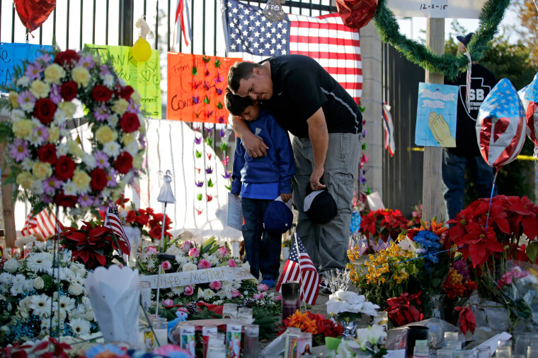 Image:A man and his son pay their respects at a makeshift memorial site