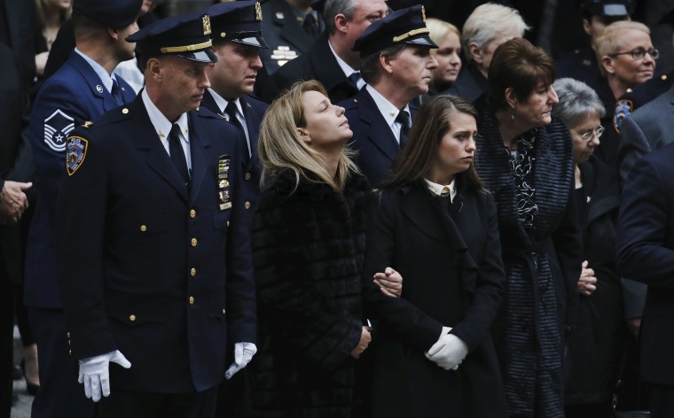 Image: Wife Christine Lemm and daughter Brooke of NYPD officer Joseph Lemm, who was killed on duty in Afghanistan, react after funeral services at St Partick's Cathedral in the Manhattan borough of New York