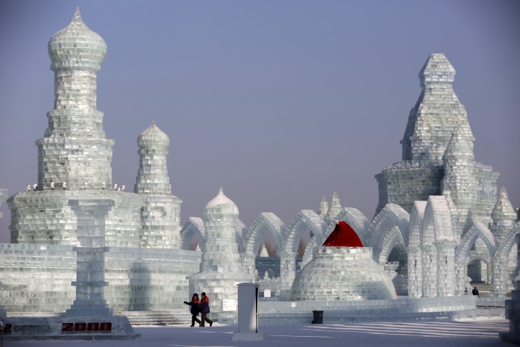 Image: People look around ice sculptures ahead of the Harbin International Ice and Snow Festival in the northern city of Harbin