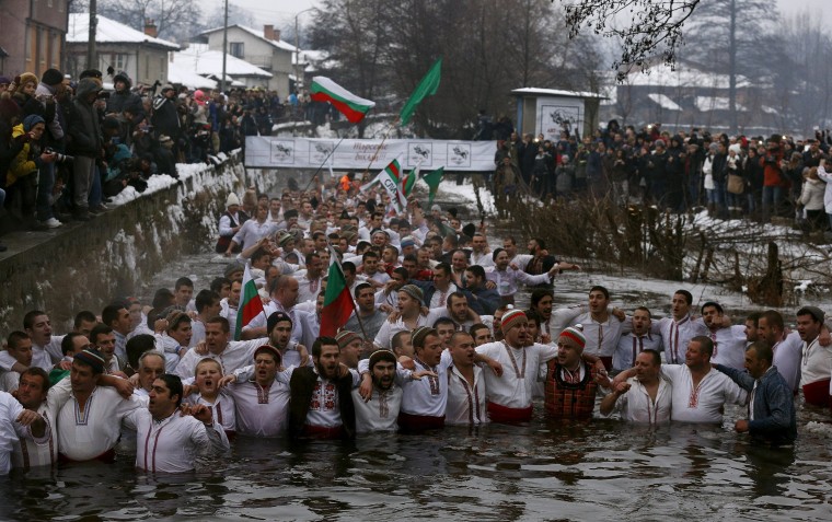 Image: Bulgarian men dance in the icy waters of the Tundzha river