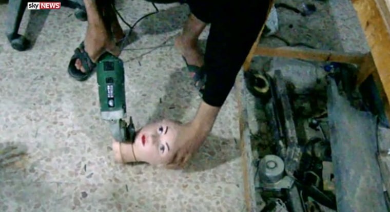 An ISIS researcher works on a mannequin at the group's lab in Raqqa, Syria.