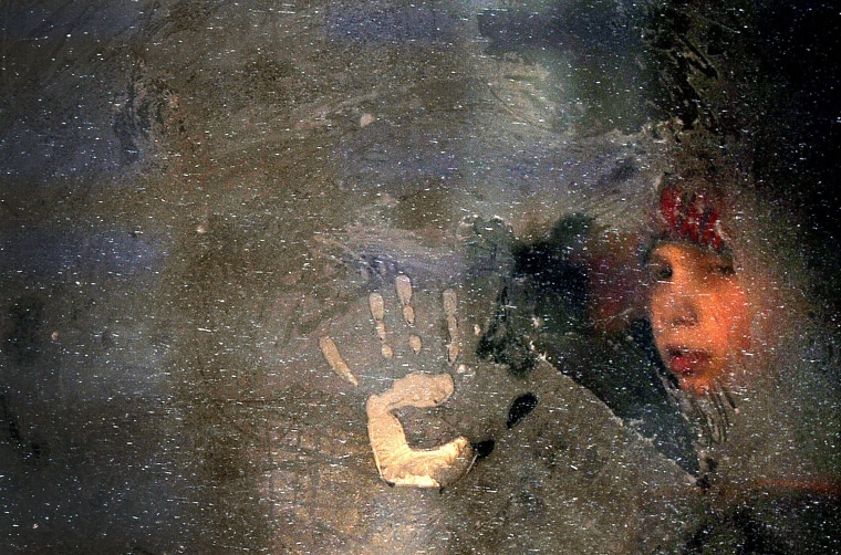 Image: A boy looks through a frozen bus window in Minsk, Belarus
