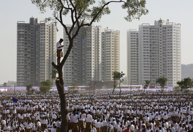 Image: A volunteer of the Hindu nationalist organisation Rashtriya Swayamsevak Sangh stands on a tree