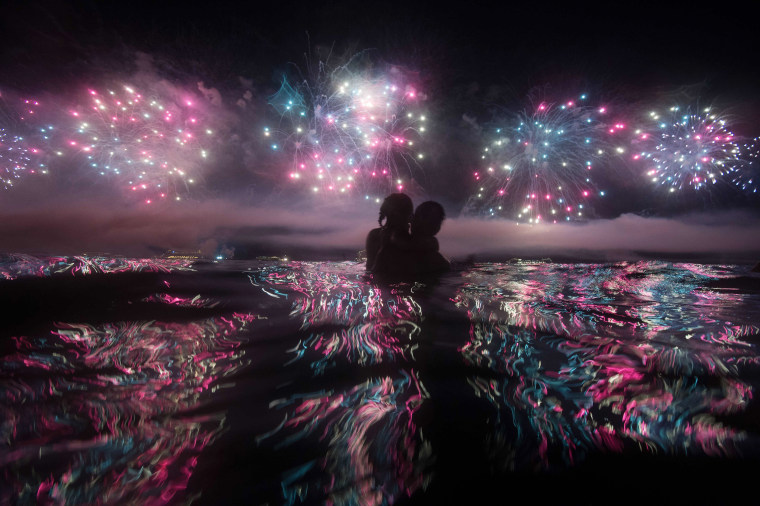 Image: A couple watches fireworks just after New Years at Copacabana beach