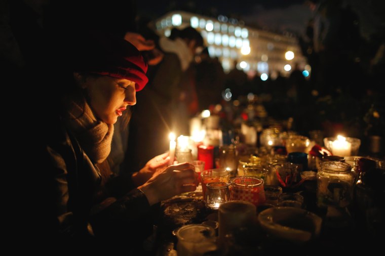 Image: People gather on the Place de la Republique square to pay tribute to the victims of last year's shooting at the French satirical newspaper Charlie Hebdo in Paris