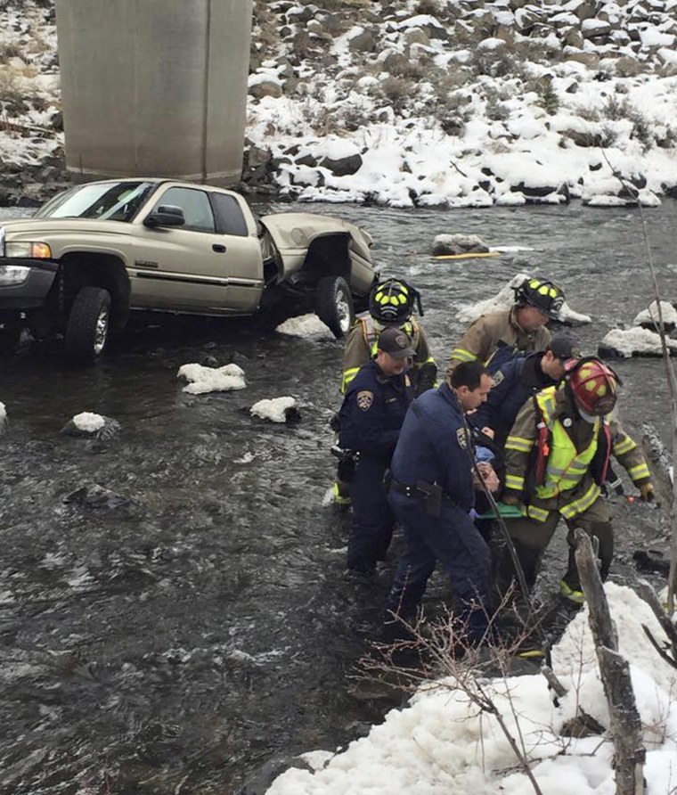 Image: Fire rescue and California Highway Patrol members carry away a man whose truck slid off Interstate 80