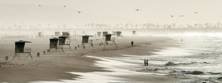 Image: People enter the water near Huntington Beach Pier
