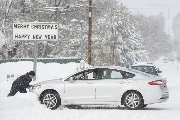 Image: Flagstaff resident Anthony Martinez pushes a motorist out of the snow