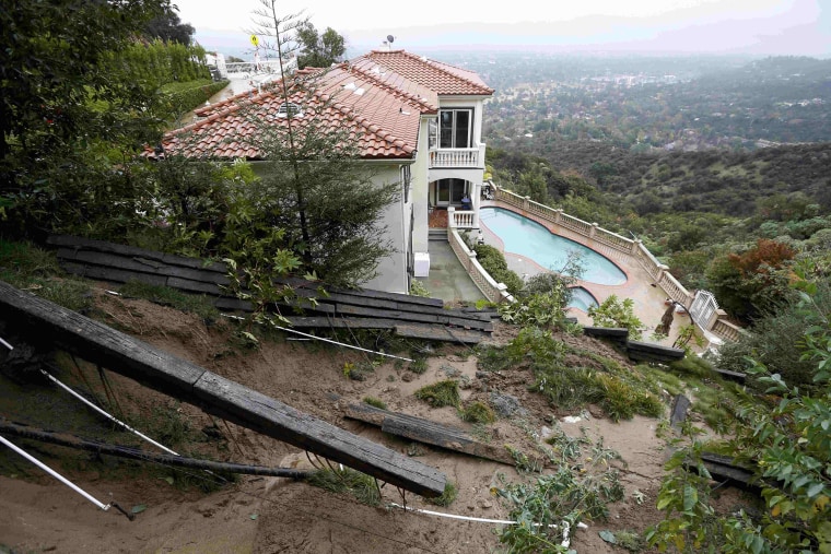 Image: A home with a fence destroyed by a mudslide is seen after El Nino-strengthened storm brought rain to Pasadena