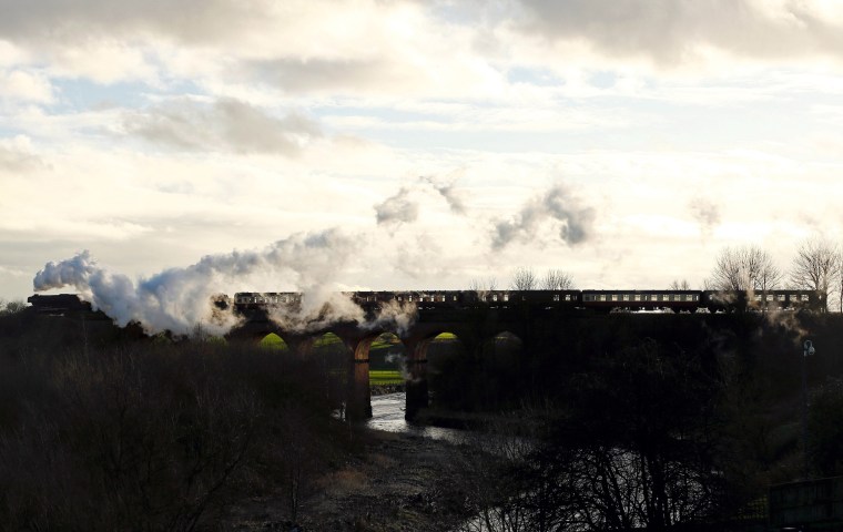 Image: The Flying Scotsman steam engine passes over a viaduct as it leaves East Lancashire Railway in Bury