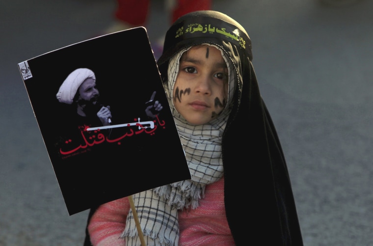 Image: A Shi'ite Muslim girl holds a picture of Shi'ite Muslim cleric Nimr al-Nimr as she takes part in a protest rally in Islamabad