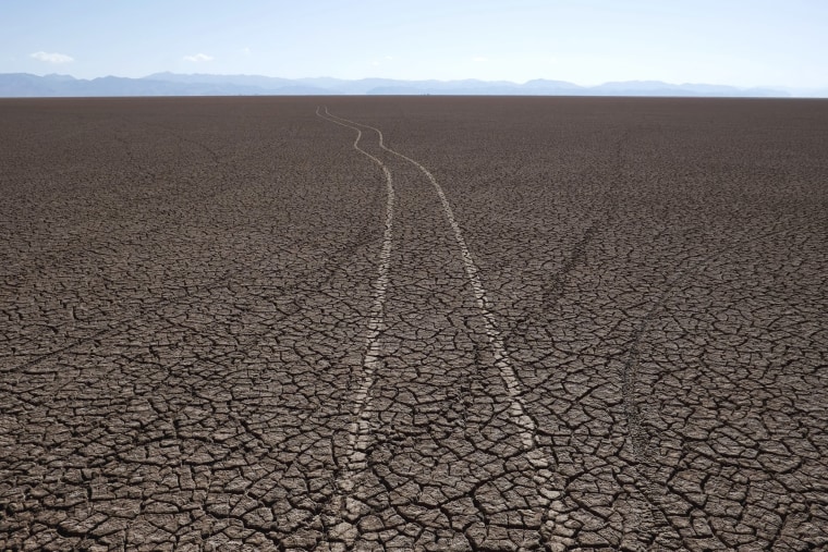 Image: Marks of car tires are seen on the dried Poopo lakebed in the Oruro Department, south of La Paz, Bolivia
