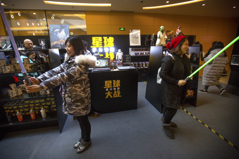 Woman play with lightsabers at a Star Wars merchandise shop at a shopping mall in Beijing, Saturday, Jan. 9.