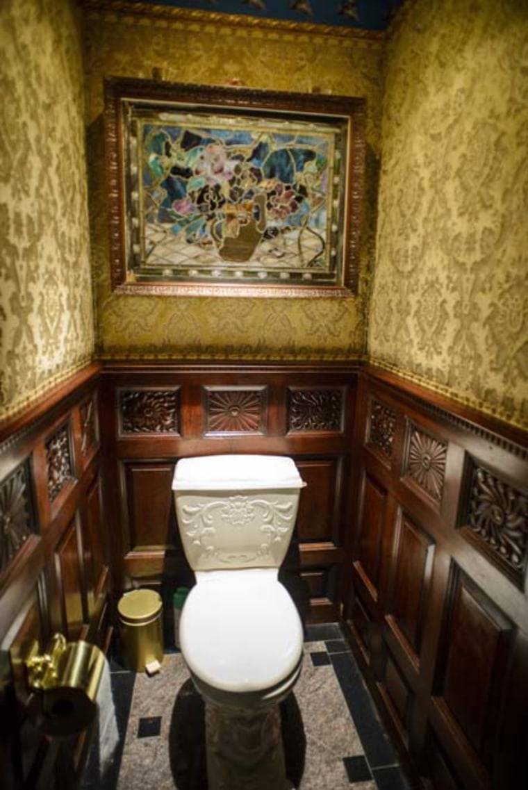 A Tiffany-stained glass sits above a toilet.