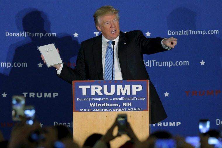 Image: U.S. Republican presidential candidate Donald Trump holds a Bible given to him by an audience member at a campaign rally in Windham