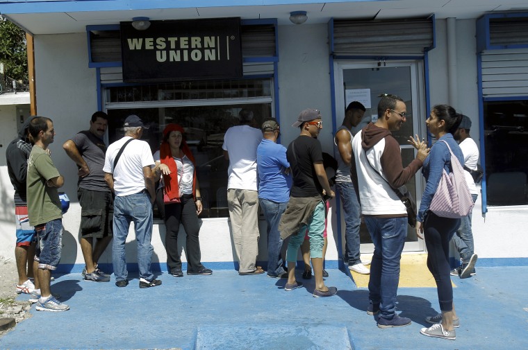 Image: Cuban migrants line up while waiting outside Western Union branch in the town of La Cruz, Costa Rica