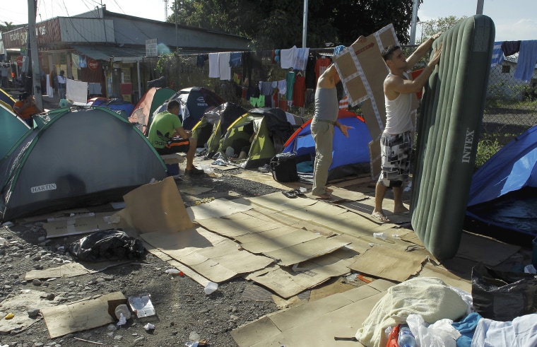Image: A Cuban migrant removes an inflatable mattress at a makeshift camp at a border post with Panama in Paso Canoas