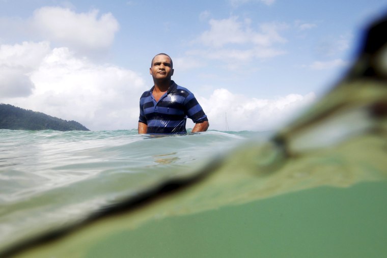 Image: A Cuban migrant freshens up in the sea after crossing the border from Colombia through the jungle into La Miel, Panama