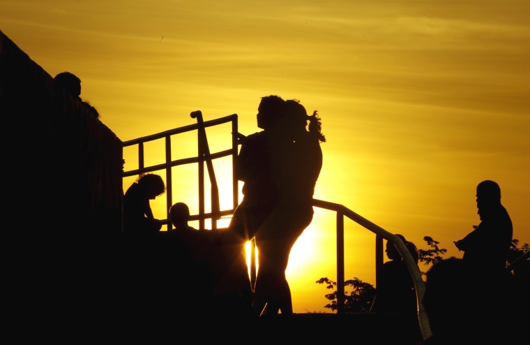 Image: Cubans migrants chat as the sun sets in the town of La Cruz