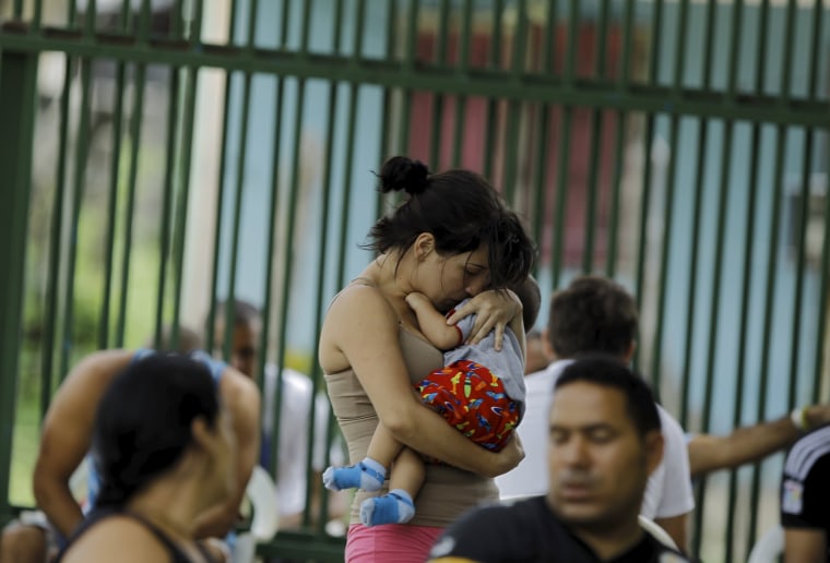 Image: Cuban migrant Sylenay Valle holds her 10 month-old son Yeryko at a shelter in Liberia