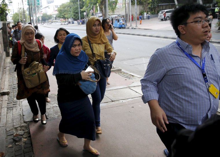 Image: Workers run as they are evacuated from their office