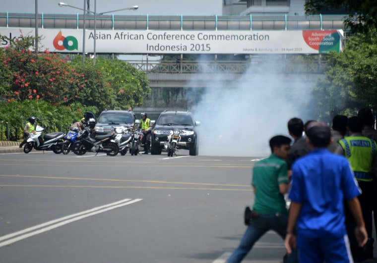 Image: Police (Left) hide behind vehicles during an exchange of gunfire with suspect