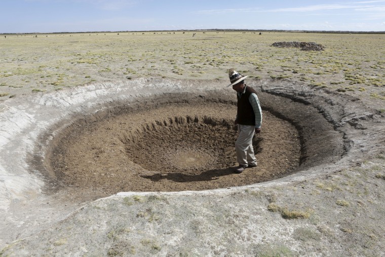 Image: Farmer Sindulfo Fernandez inspects a dried watering hole for llamas in Orinoca