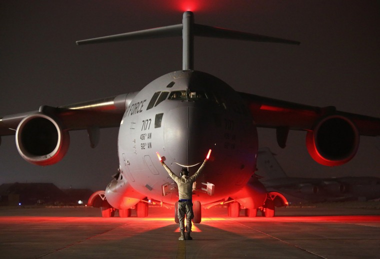 Image: An airman guides a U.S. Air Force C-17 Globemaster after it returned from delivering cargo to Baghdad