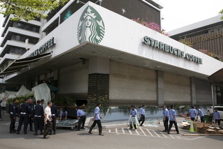 Image: Workers clean debris outside a Starbucks cafe, near the site of a militant attack, in Jakarta