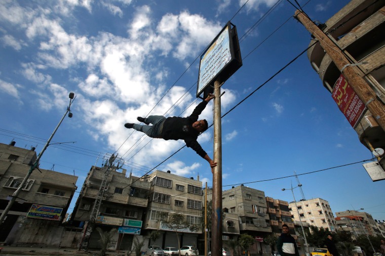 Image: A Palestinian youth demonstrates his parkour skills on a street in Gaza City