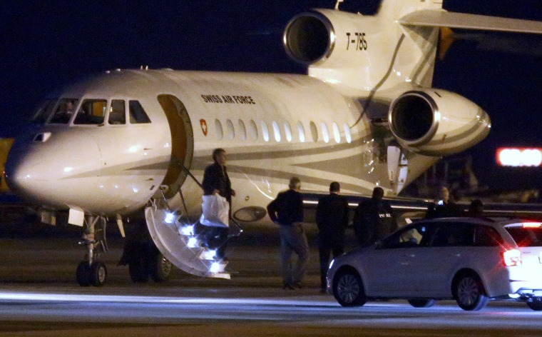 Image: People walk off a plane carrying three Iranian-Americans, who left Tehran under a prisoner swap, after it landed at Cointrin airport in Geneva