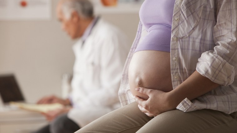 Pregnant woman having checkup in doctor's office