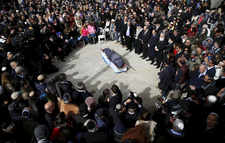 Image: Family and friends surround the body of Dafna Meir, 38, during her funeral at a cemetery in Jerusalem