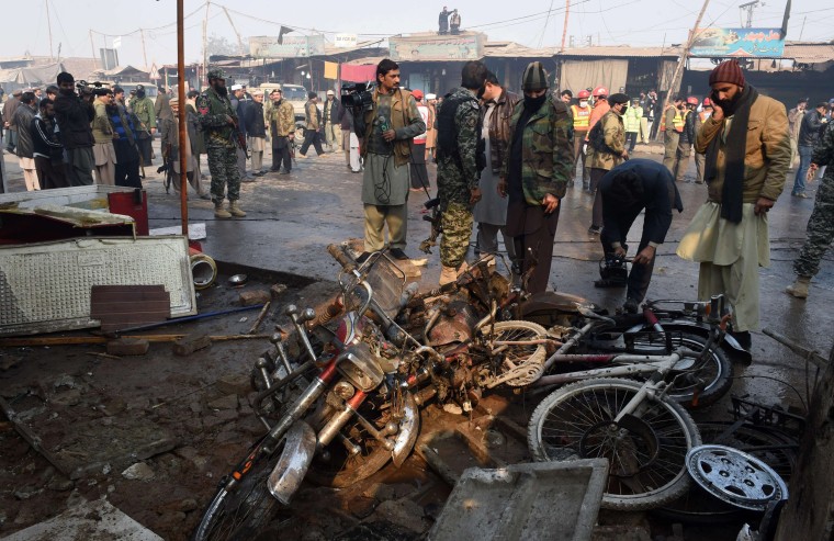 Image: Pakistani security officials examine the site of a suicide bomb attack on the outskirts of Peshawar