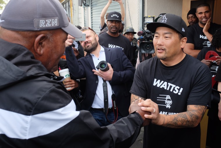 Chef Roy Choi shakes hands with former Cleveland Browns fullback Jim Brown, who helped orchestrate a 1992 truce between rival street gangs in Watts, during Locol's grand opening.