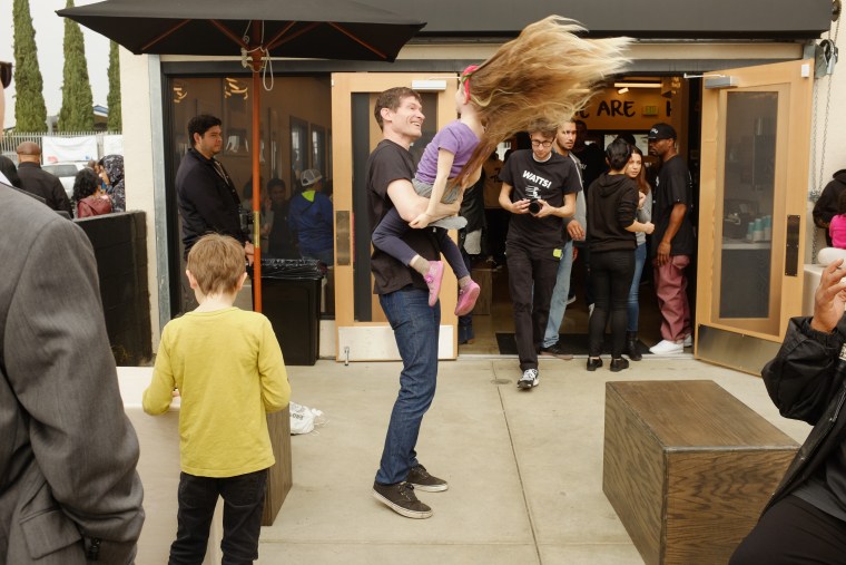 Daniel Patterson, partner with Roy Choi at Locol, plays with his five-year-old daughter Louise during the restaurant's grand opening celebration.