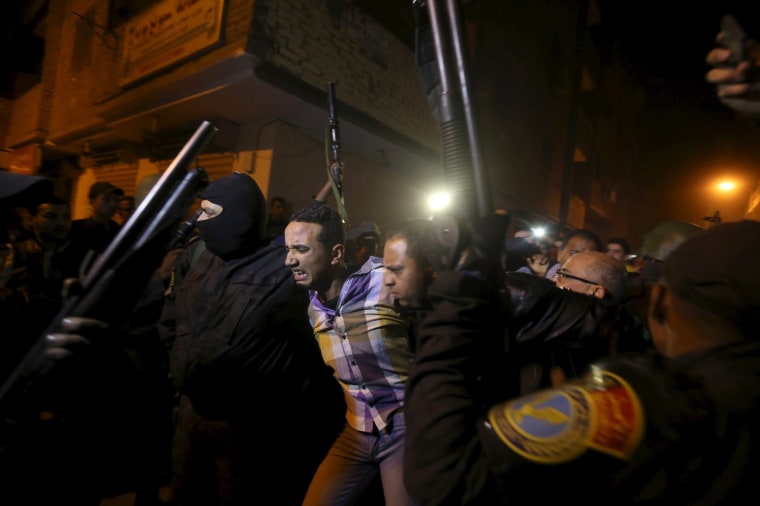 Image: Security forces detain a man at the scene of a bomb blast in a main street in Giza