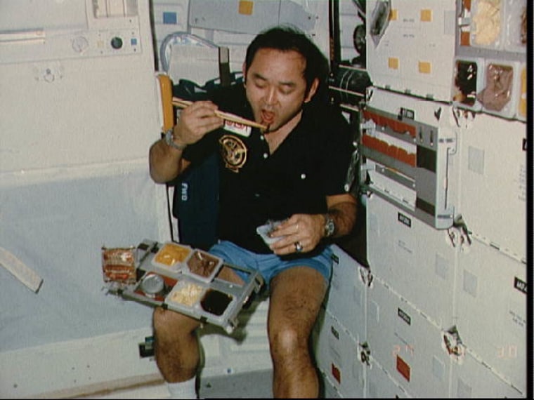 Ellison Onizuka eating on the space shuttle Discovery during STS-51-C, his first spaceflight.
