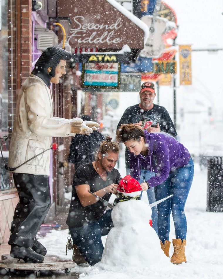 Image: People decorate a snowman in Nashville