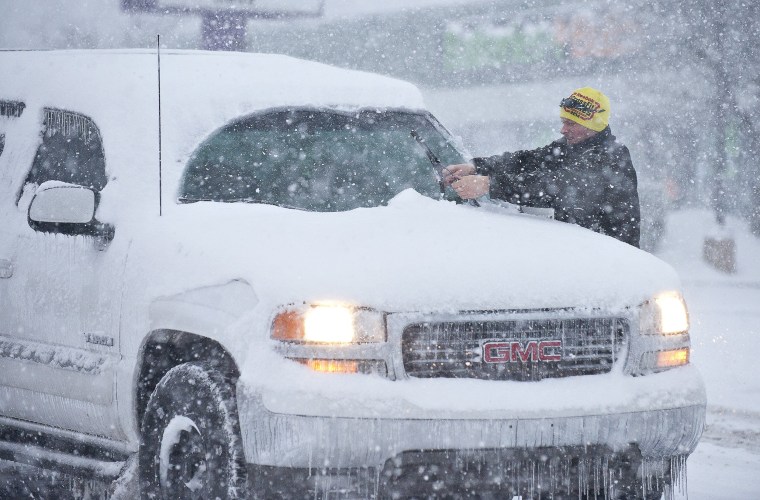 Image: A man cleans his windshield wipers off at a stop light in Bowling Green, Ky.