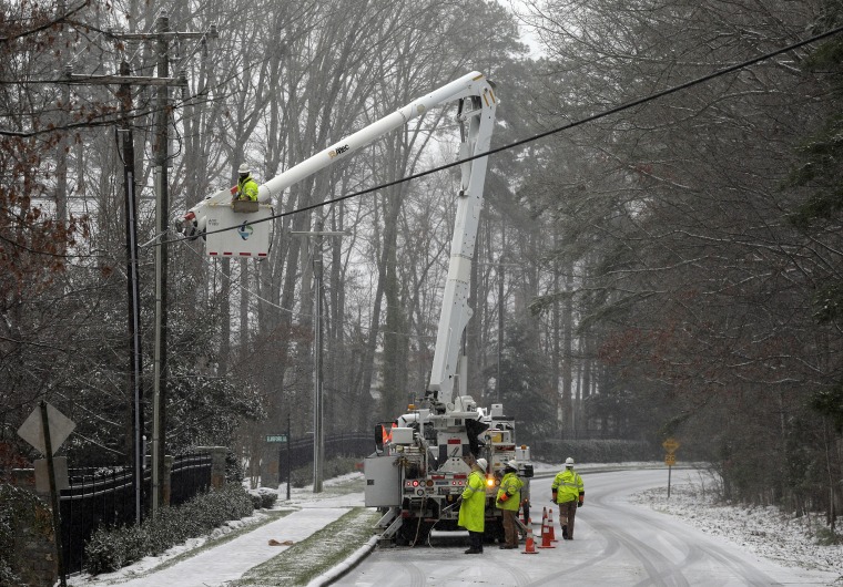 Image: Duke Energy employees work to restore power in a neighborhood in Matthews, N.C.