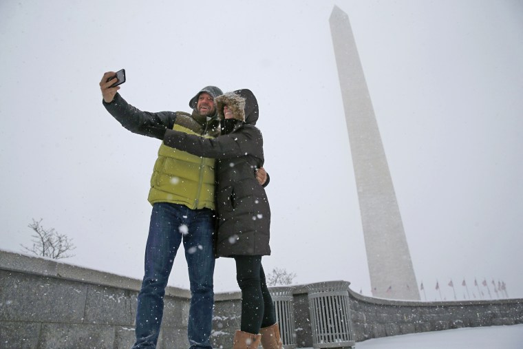 Image: A couple pauses to take a 'selfie' in the freshly fallen snow near the Washington Monument after snowstorm arrived in Washington