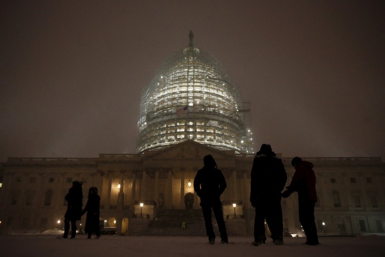 Image: People gather to watch the falling snow at the U.S. Capitol in Washington