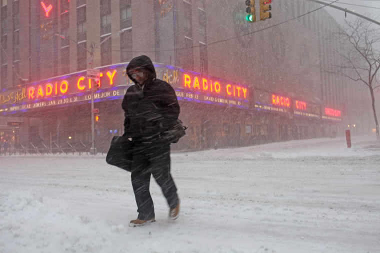 A pedestrian crosses the street through blowing snow in front of Radio City Music Hall in New York City on Jan. 23.