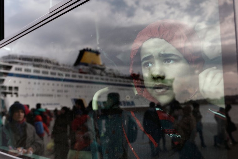 Image: Refugees and migrants arrive at the port of Piraeus, near Athens