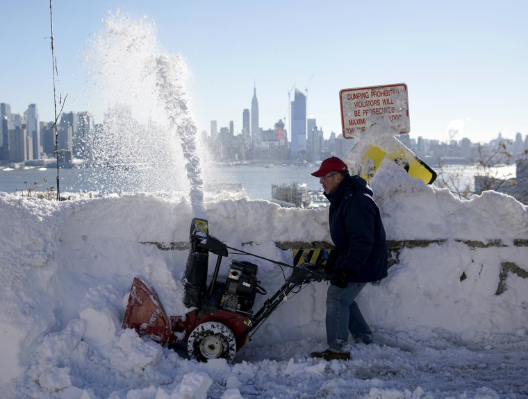 Image: A resident removes snow away from the entrance to his home in Union City
