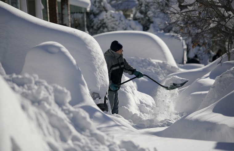 Image: A resident shovels snow away from the entrance to his home in Union City
