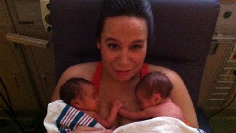 Mom holds her preemie twins, who are holding hands