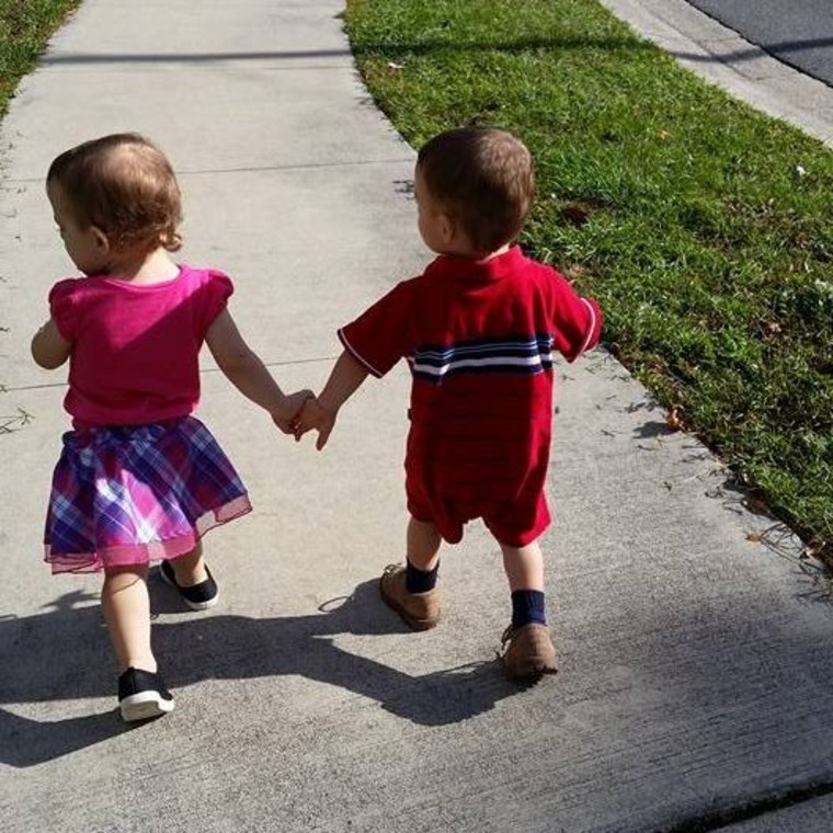 twin siblings holding hands